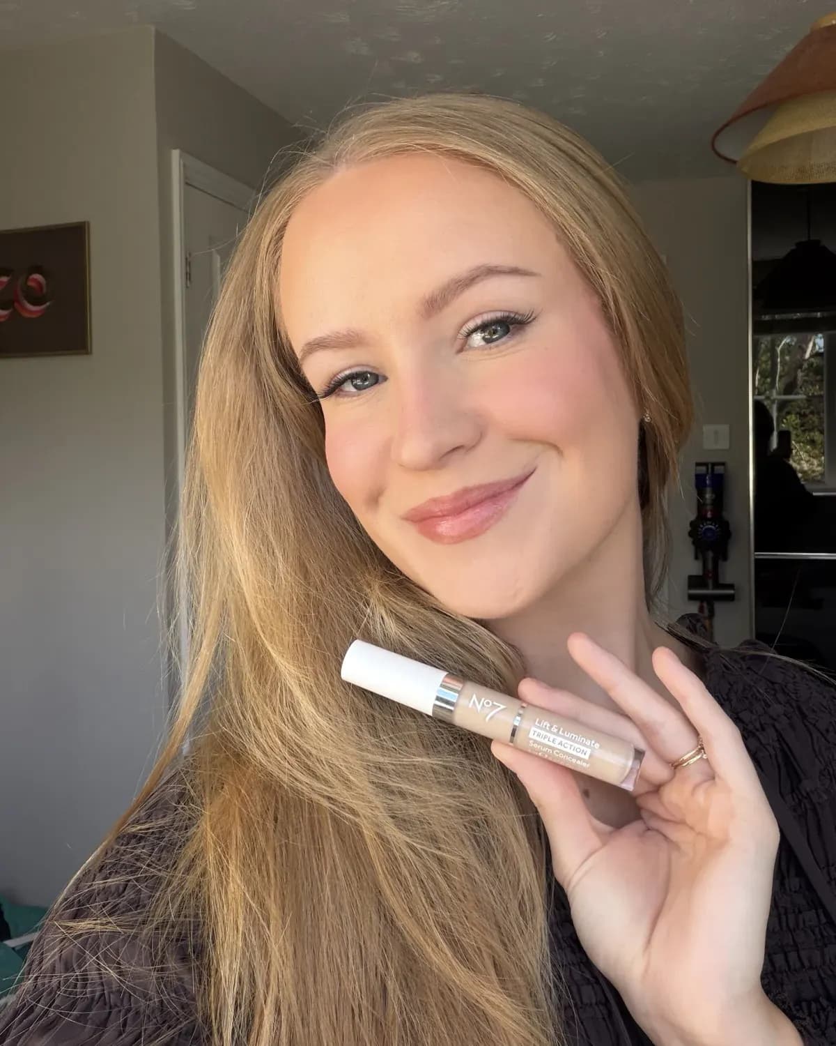Me holding the No7 Lift & Luminate Triple Action Serum Concealer in shade Light
