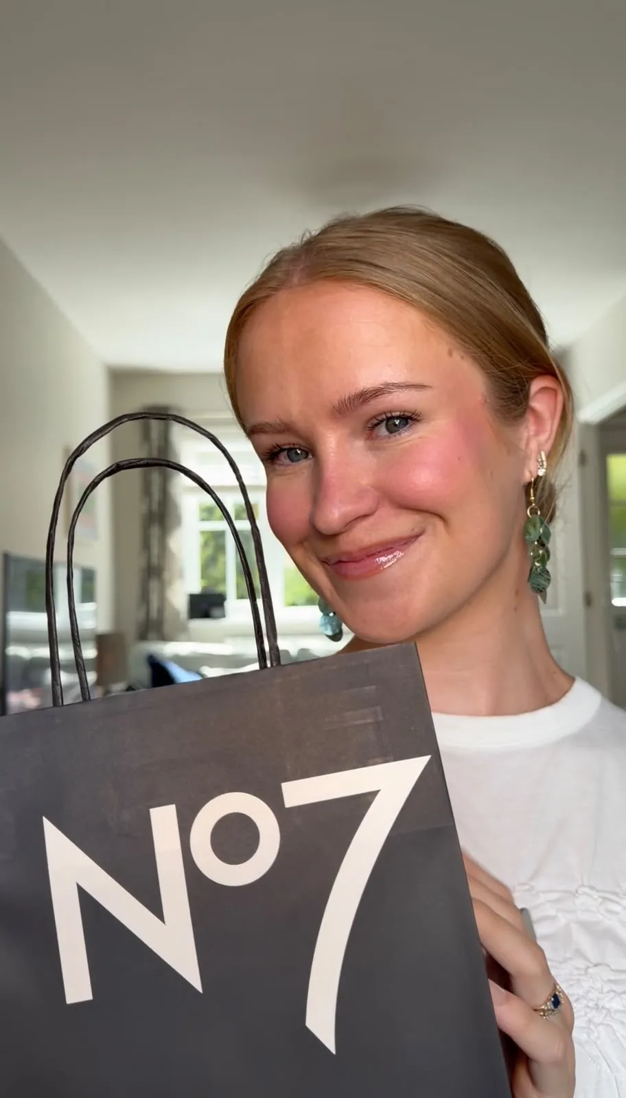 Abbie McDonnell holding a No7 paper shopping bag from Boots